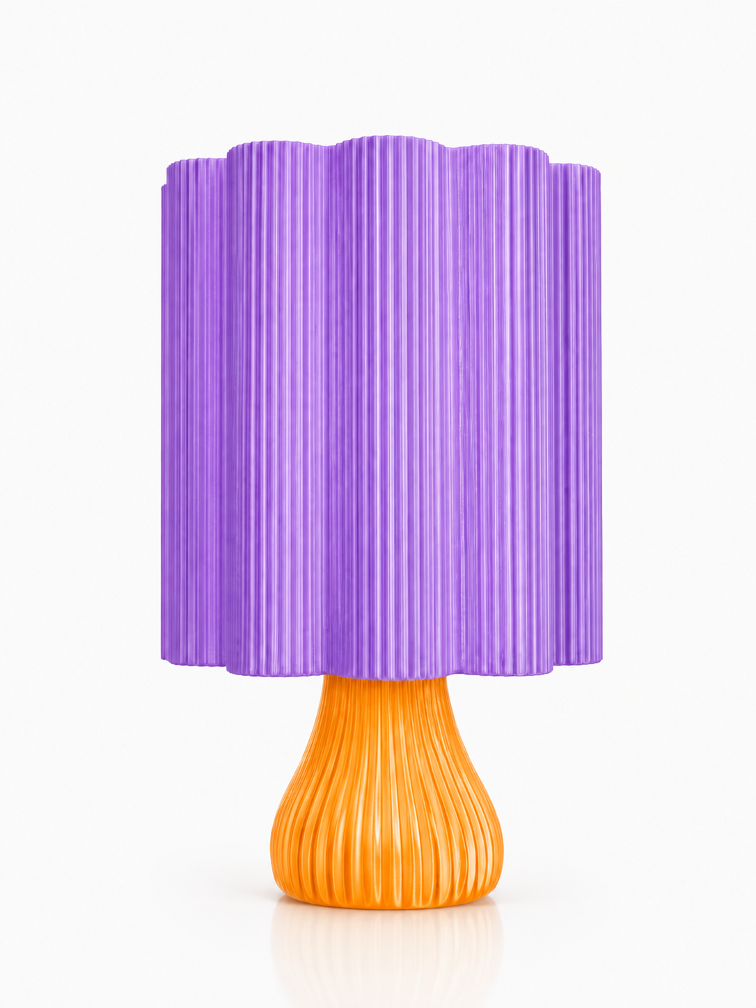 A modern table lamp with a pleated purple shade and a ribbed orange base, shown against a plain white background.